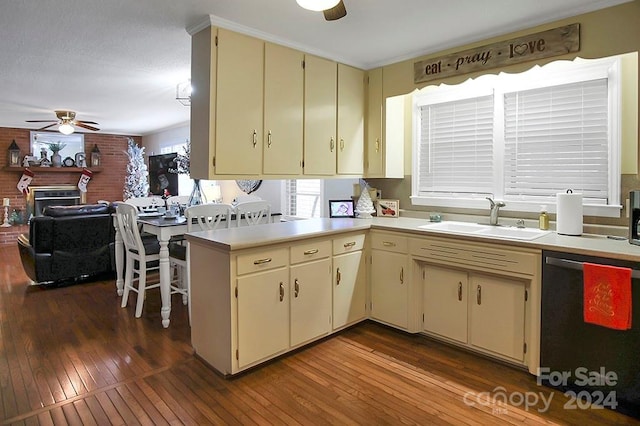 kitchen with dishwasher, wood-type flooring, sink, and cream cabinets