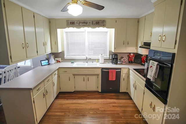 kitchen featuring sink, light hardwood / wood-style flooring, black appliances, and cream cabinetry