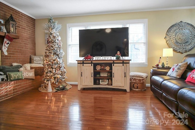 living room featuring ornamental molding, brick wall, and hardwood / wood-style flooring