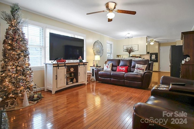 living room featuring wood-type flooring and ornamental molding