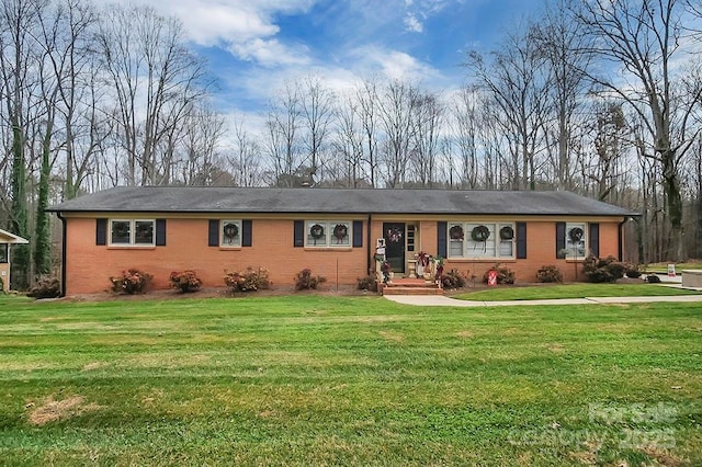 ranch-style home featuring a front yard and brick siding