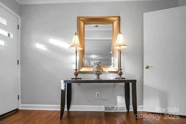 room details with ornamental molding, visible vents, baseboards, and wood finished floors