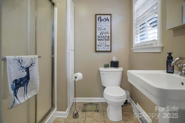 full bathroom featuring baseboards, toilet, tile patterned flooring, a shower stall, and a sink