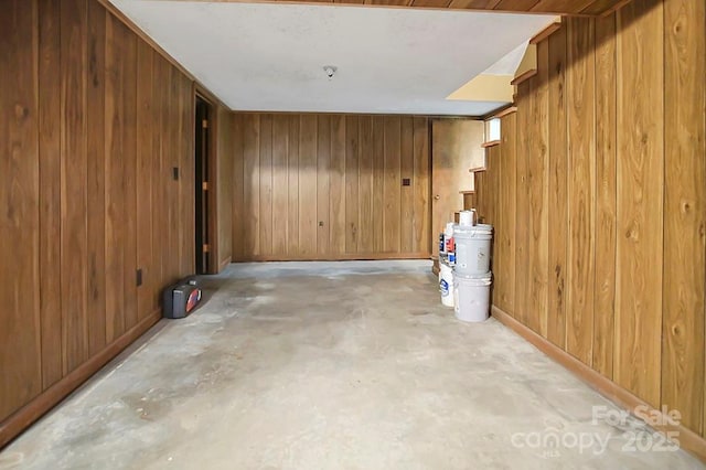 spare room featuring concrete flooring and wooden walls