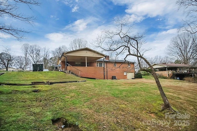 rear view of house featuring a lawn and brick siding