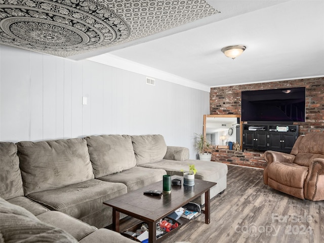 living room featuring hardwood / wood-style floors, crown molding, and wooden walls