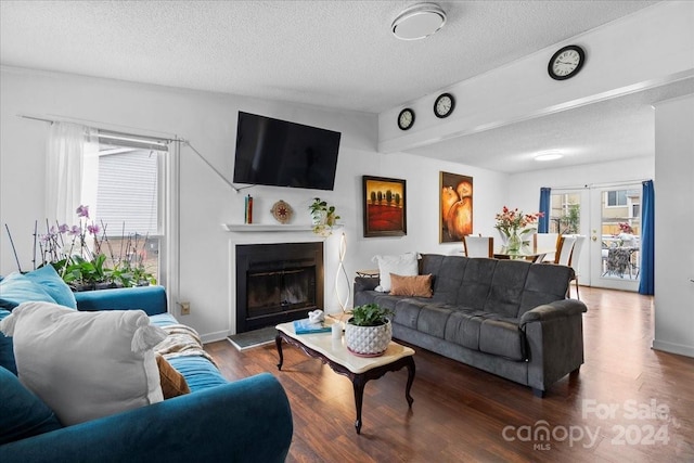 living room featuring a textured ceiling, dark wood-type flooring, and french doors