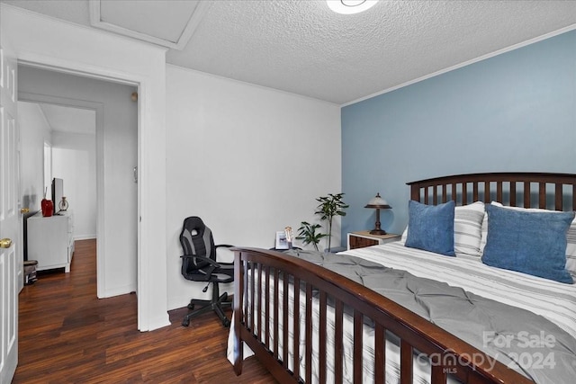 bedroom featuring dark hardwood / wood-style floors, crown molding, and a textured ceiling