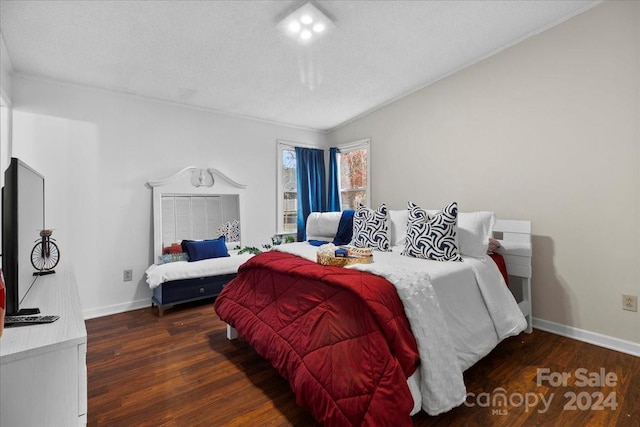 bedroom featuring a textured ceiling, dark hardwood / wood-style floors, and lofted ceiling