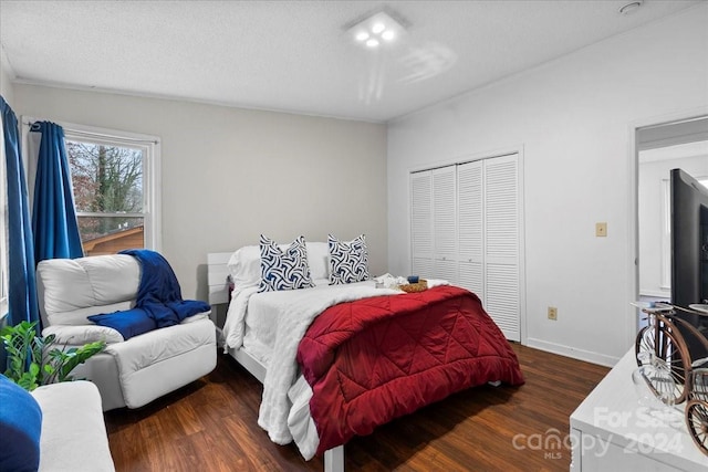 bedroom with a textured ceiling, a closet, and dark wood-type flooring