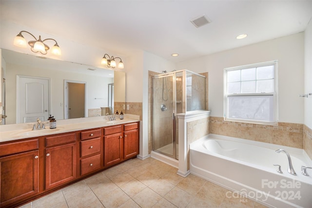 bathroom featuring plus walk in shower, vanity, and tile patterned floors