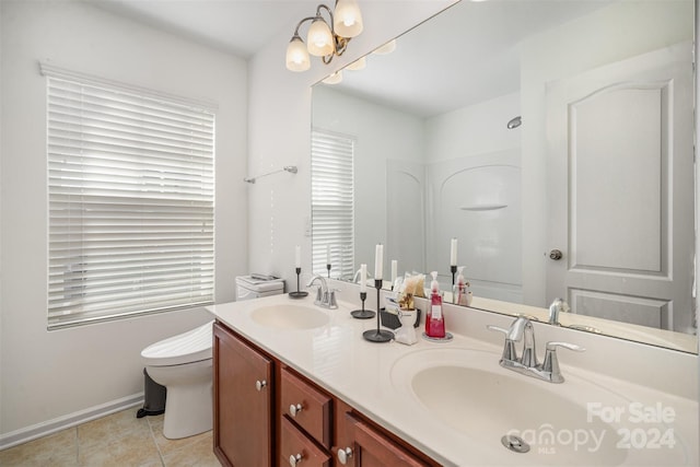 bathroom with tile patterned floors, toilet, vanity, and a notable chandelier