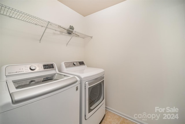 washroom featuring independent washer and dryer and light tile patterned flooring