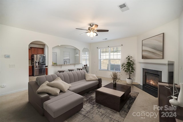 living room featuring dark colored carpet and ceiling fan