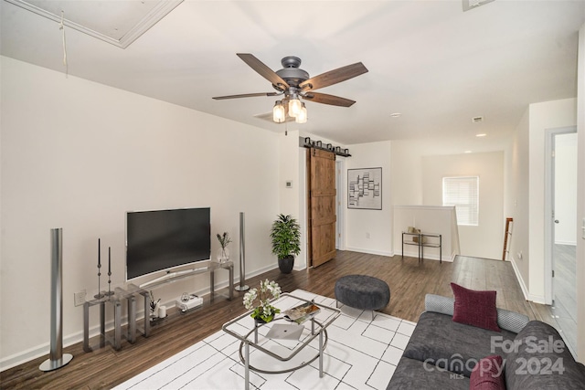 living room with hardwood / wood-style floors, ceiling fan, and a barn door