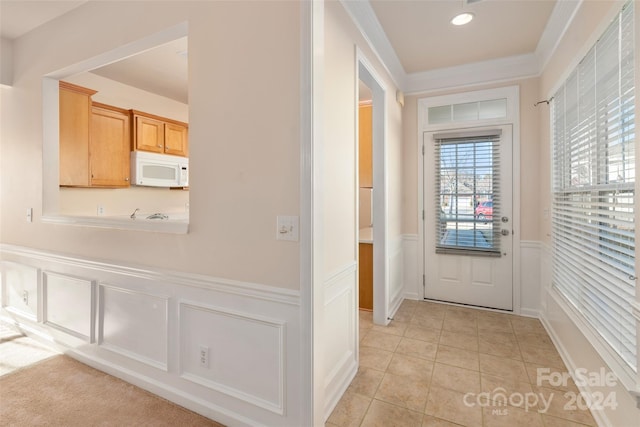 entryway featuring ornamental molding and light tile patterned flooring