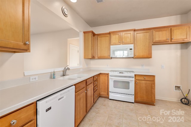 kitchen featuring sink, light tile patterned floors, and white appliances