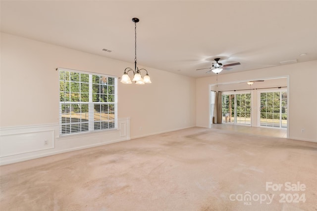 carpeted empty room with ceiling fan with notable chandelier