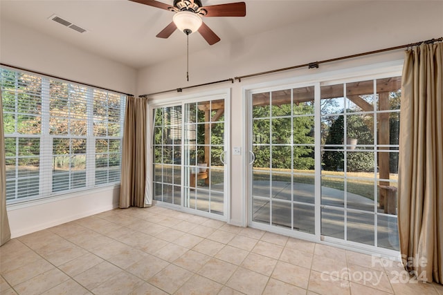 unfurnished sunroom with ceiling fan