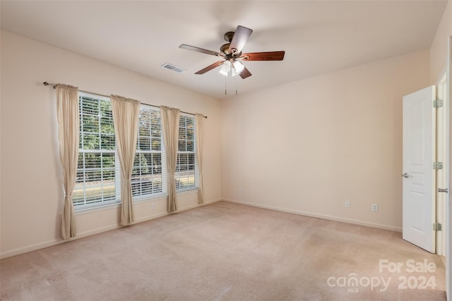 carpeted spare room featuring ceiling fan