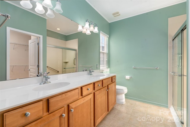 bathroom featuring tile patterned flooring, crown molding, toilet, a shower with door, and vanity