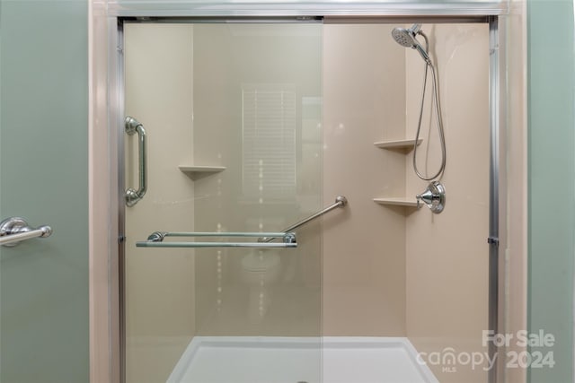 bathroom with a shower with door