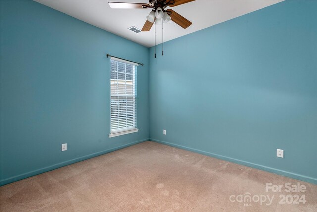 carpeted spare room with ceiling fan