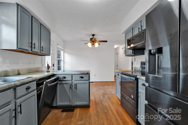 kitchen featuring gray cabinetry, ceiling fan, black range with electric cooktop, stainless steel fridge with ice dispenser, and light hardwood / wood-style floors