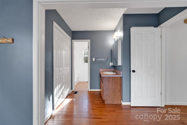 bathroom with a textured ceiling, vanity, and hardwood / wood-style flooring