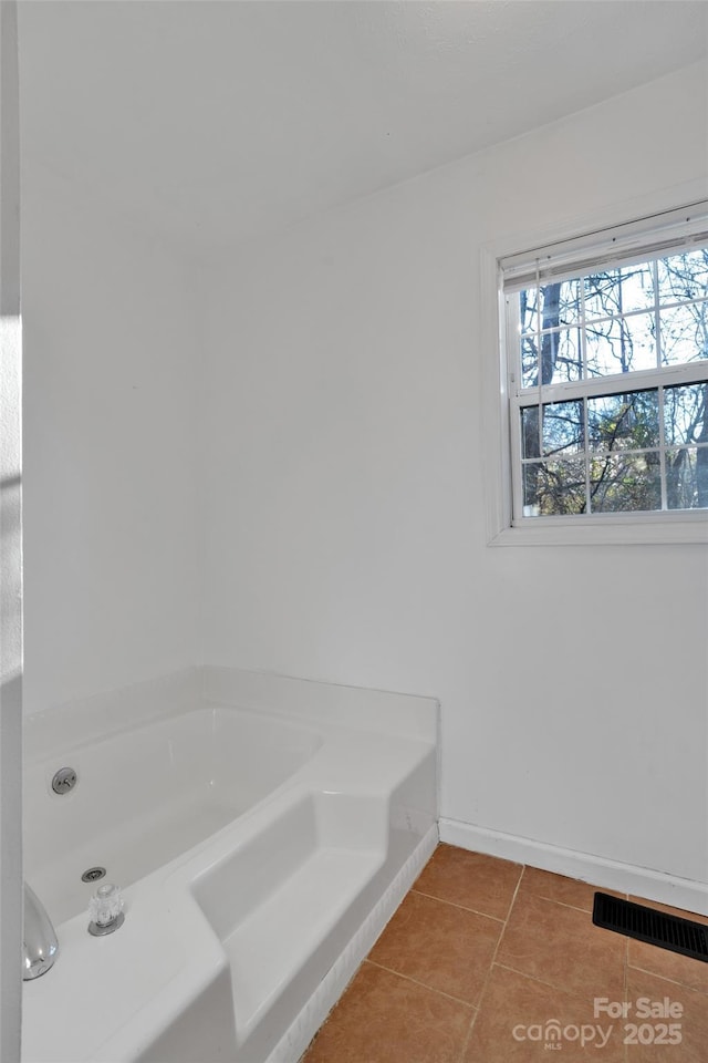 bathroom featuring tile patterned flooring and a tub to relax in