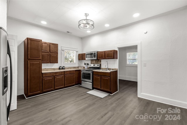 kitchen with a chandelier, stainless steel appliances, a wealth of natural light, and dark hardwood / wood-style floors