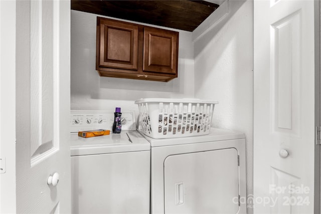 washroom with cabinets and washer and dryer