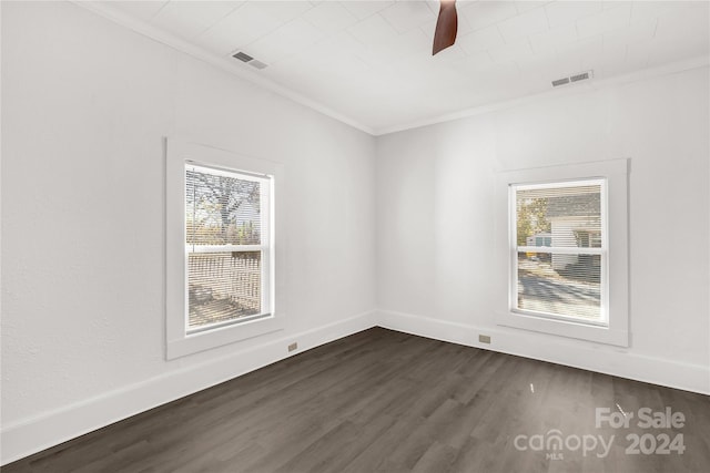 empty room with dark hardwood / wood-style flooring, a wealth of natural light, crown molding, and ceiling fan