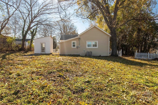 back of property with a lawn and central air condition unit