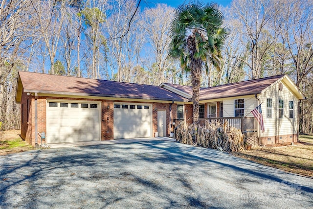 ranch-style home featuring covered porch and a garage