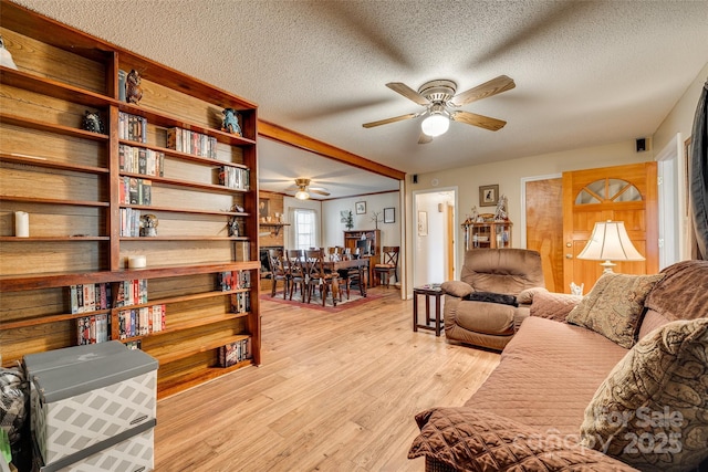 living room featuring ceiling fan, a textured ceiling, and light hardwood / wood-style flooring