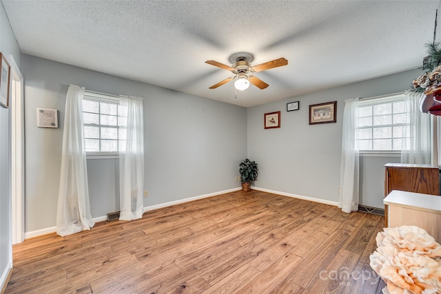 interior space with ceiling fan, light hardwood / wood-style flooring, and a textured ceiling