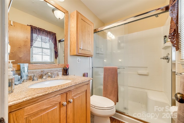 bathroom with vanity, an enclosed shower, and toilet