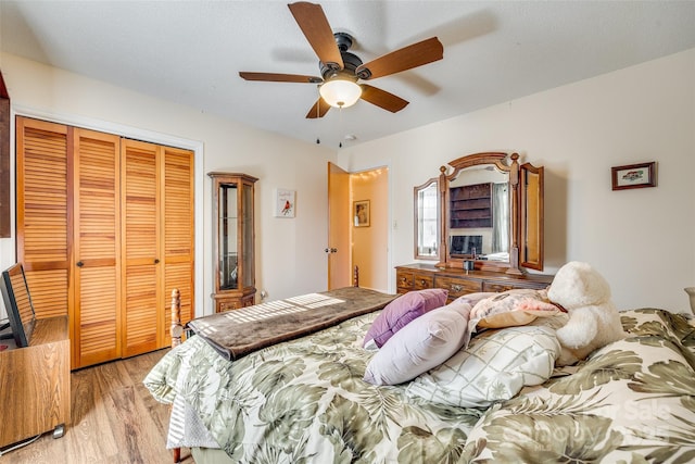 bedroom featuring ceiling fan, a closet, light hardwood / wood-style floors, and a textured ceiling