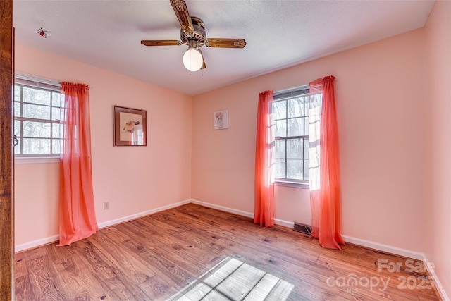 spare room featuring ceiling fan, a textured ceiling, and light hardwood / wood-style flooring