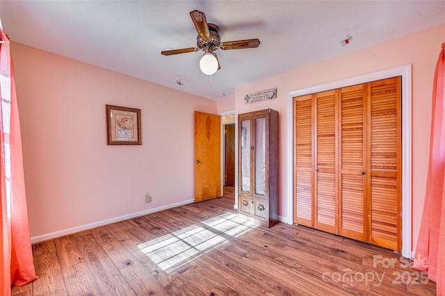 unfurnished bedroom with ceiling fan, light hardwood / wood-style floors, and a closet