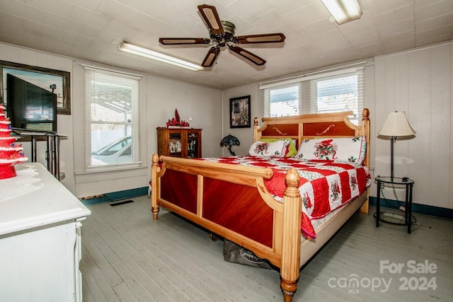 bedroom featuring multiple windows, ceiling fan, and hardwood / wood-style floors