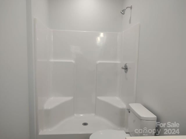 bathroom featuring a shower and toilet