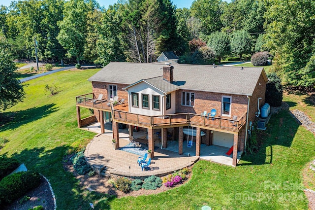 back of house featuring a lawn, a patio area, a wooden deck, and a garage