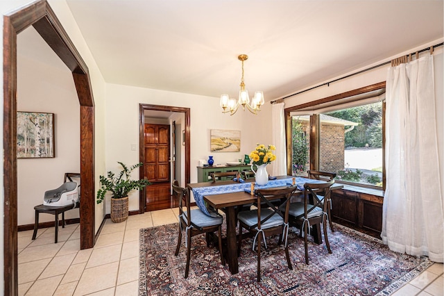 tiled dining room featuring a chandelier