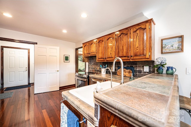 kitchen featuring tasteful backsplash, tile countertops, stainless steel electric range oven, and dark hardwood / wood-style floors