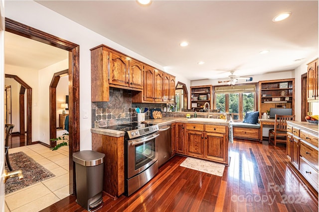 kitchen with ceiling fan, sink, hardwood / wood-style floors, decorative backsplash, and appliances with stainless steel finishes