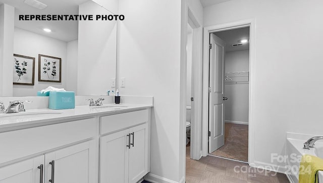 bathroom with vanity, toilet, and a washtub