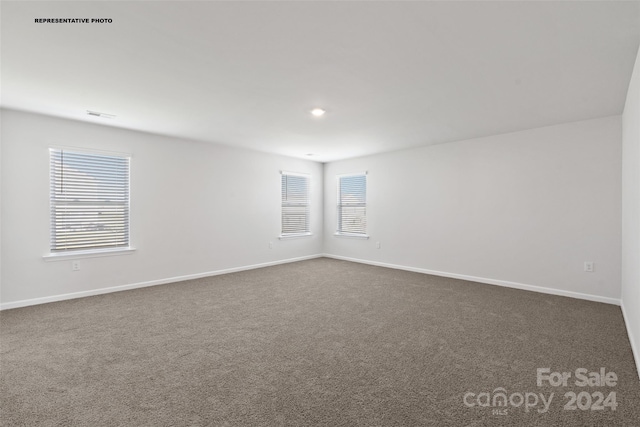 unfurnished room with dark carpet