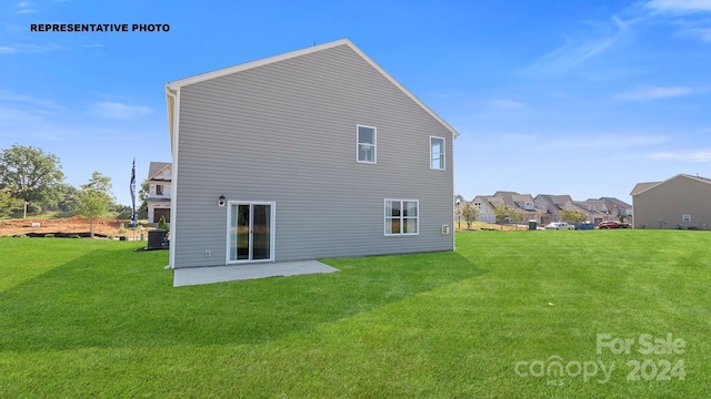 back of house featuring a lawn and a patio area